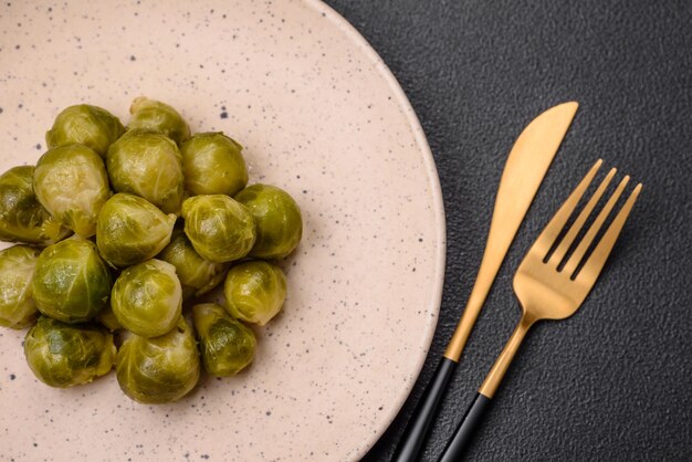Фото Вкусная вареная брюссельская капуста на керамической тарелке на темном бетонном фоне вегетарианская еда