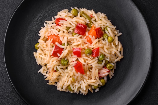 Delicious boiled rice with vegetables peppers carrots peas and asparagus beans
