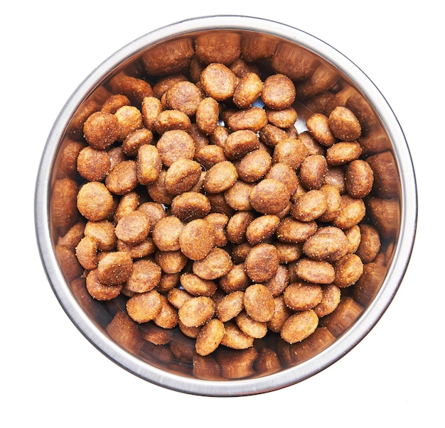 Delicious bowl of dog food balls over isolated white background