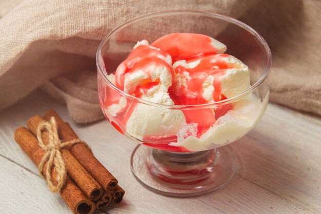 Delicious bowl of vanila ice cream with strawberry topping and cinnamon