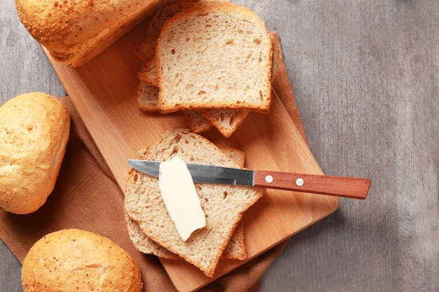 Delicious bread and piece of butter on wooden table