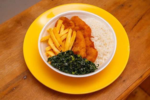 Delicious breaded chicken dish with rice, beans and cabbage