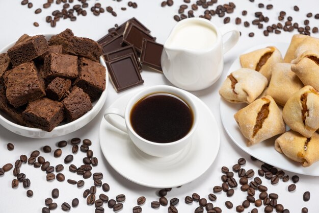 Photo delicious breakfast aromatic coffee in a cup milk jug chocolate and cake cubes