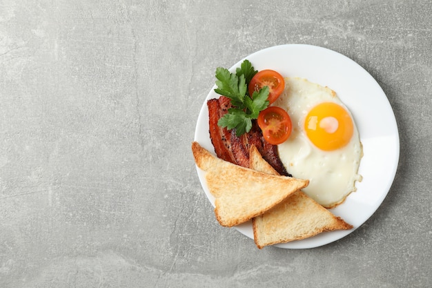 Delicious breakfast or lunch with fried eggs on grey surface, top view