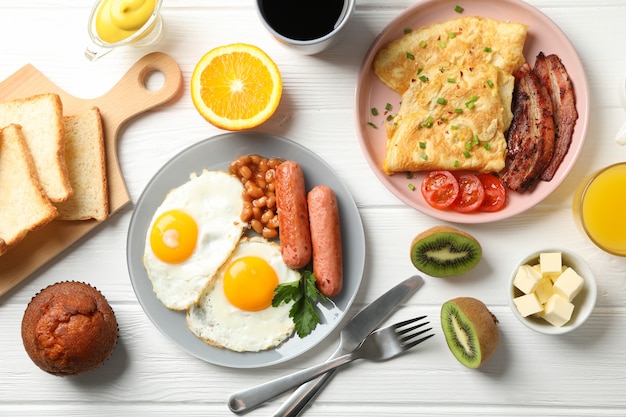 Delicious breakfast or lunch with fried eggs on white wooden table, top view