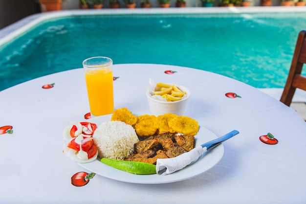 Delicious breakfast near a crystal clear pool Traditional breakfast with orange juice served near a swimming pool