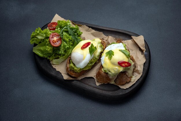 Delicious breakfast poached eggs with avocado on toast Closeup