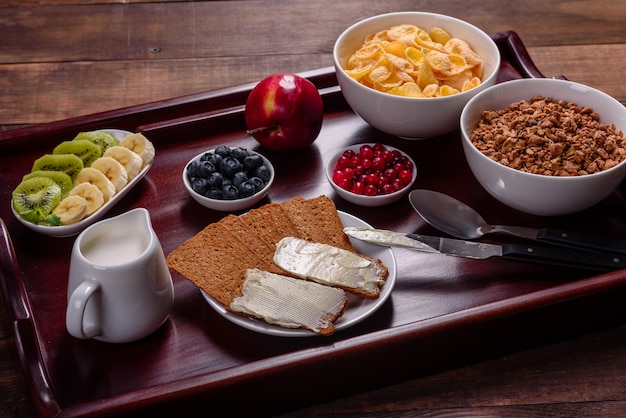 Delicious breakfast with fresh croissants and ripe berries on a beautiful wooden table