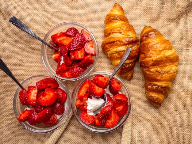 Delicious breakfast with fresh croissants and ripe berries with cream