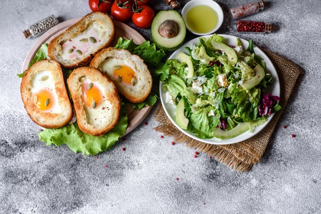 Delicious breakfast with grunts, eggs, avocado and cherry tomatoes. Pleasant morning meal with fresh sandwiches