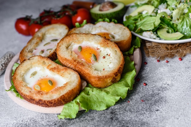 Delicious breakfast with grunts, eggs, avocado and cherry tomatoes. Pleasant morning meal with fresh sandwiches