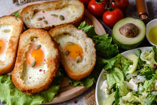 Вкусный завтрак с ворчаньями, яйцами, авокадо и помидорами черри. Приятная утренняя трапеза со свежими бутербродами