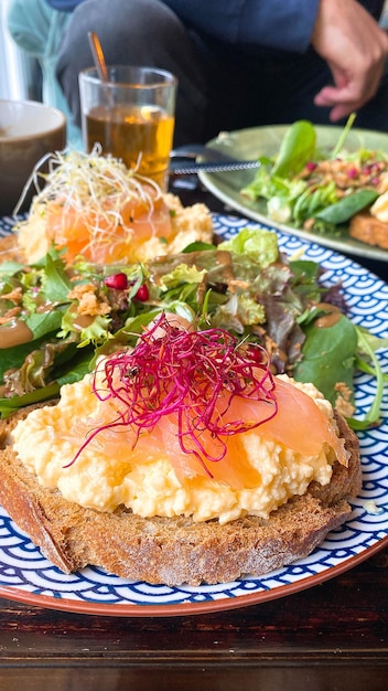 Delicious brunch platter Toast with smoked salmon scrambled eggs sprouts and salad