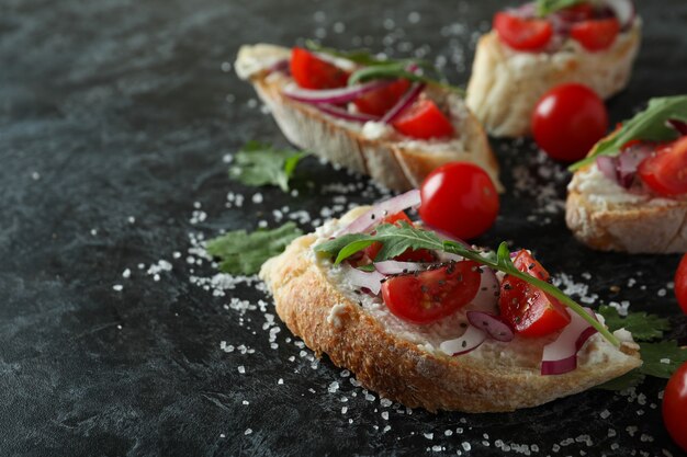 Delicious bruschetta snacks on black smokey background