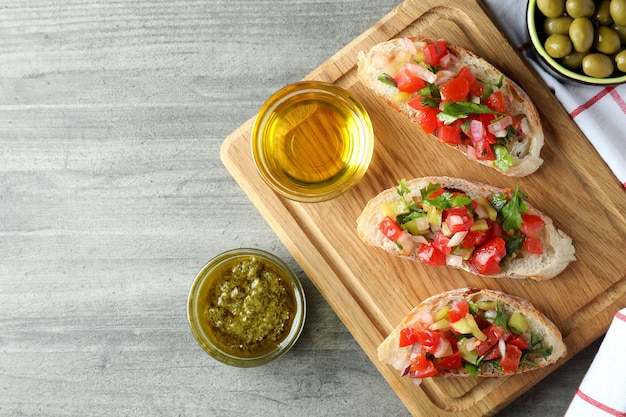 Delicious bruschetta snacks on gray textured table