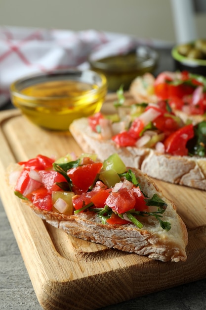 Delicious bruschetta snacks on gray textured table