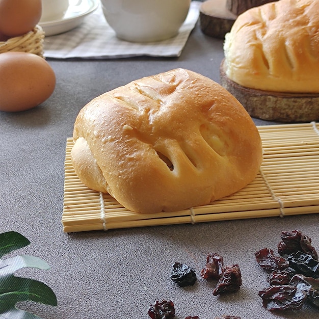 Вкусные булочки с изюмом, яйцом на светлом бетонном столе. свежая выпечка. завтрак. хлеб