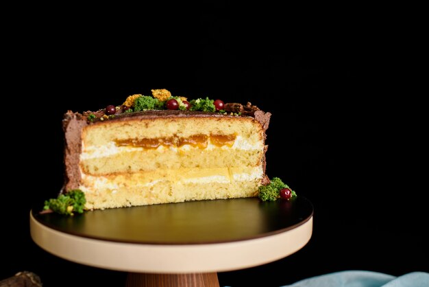 Delicious cake in the cut, a piece of cake with a layer of mango, passion fruit, vanilla cream, biscuit.