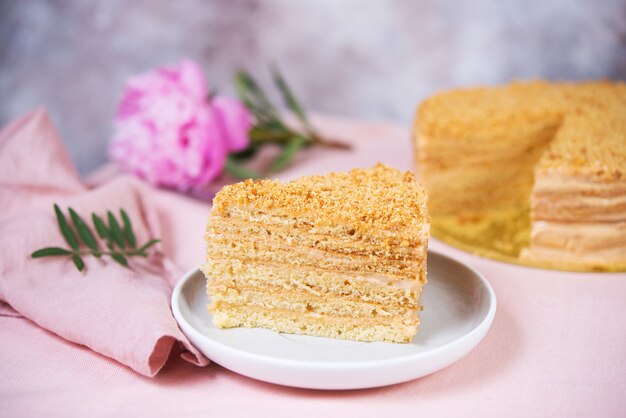 Delicious cake honey cake is on the table with flowers.