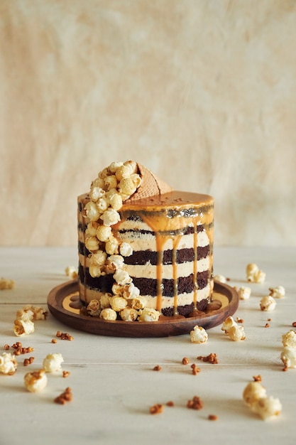 Delicious cake topped with caramel cream and a cone filled with popcorn on it