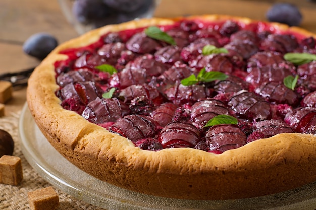 Delicious cake with fresh plums and raspberries