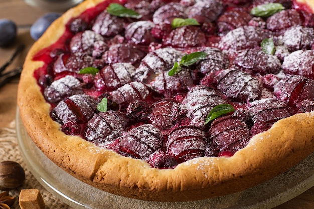 Delicious cake with fresh plums and raspberries