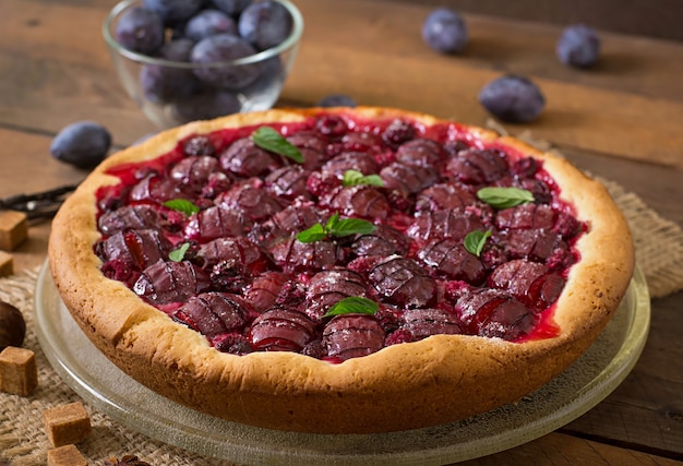 Delicious cake with fresh plums and raspberries