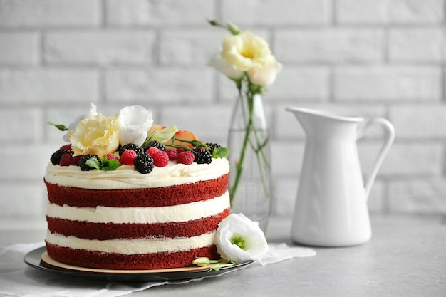 Delicious cake with fruit and berries decoration on gray table