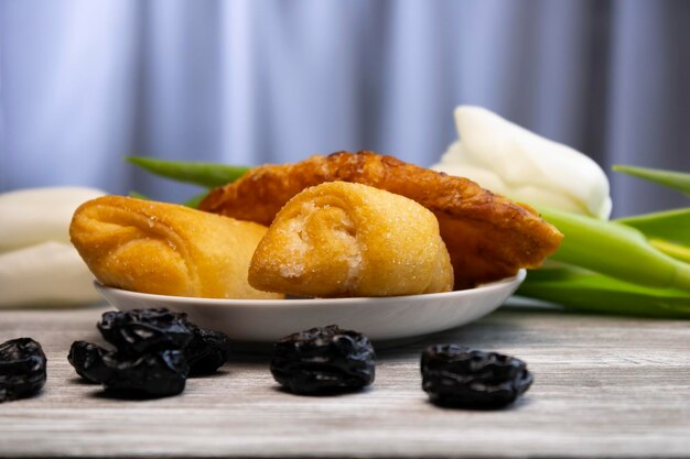 Delicious cakes with a scattering of prunes with white flowers