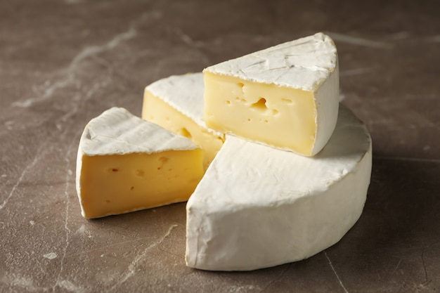 Delicious camembert cheese on gray background, close up