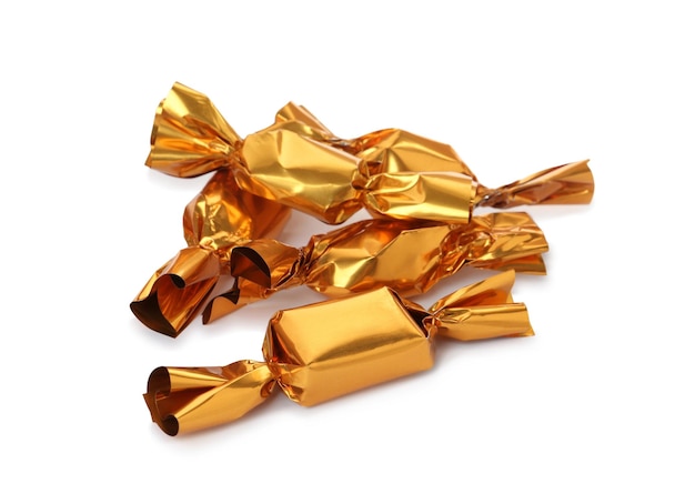 Delicious candies in golden wrappers on white background