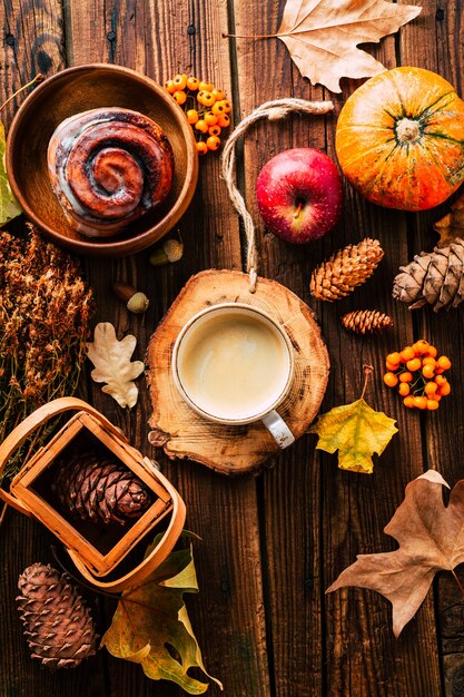 Delicious cappuccino with a bun on an autumn concept