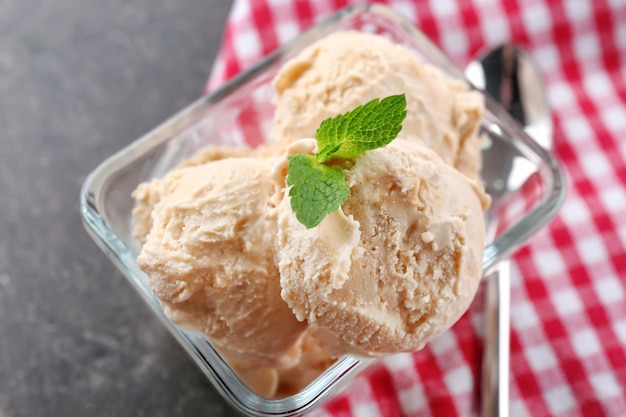 Delicious caramel ice cream in glass bowl on table