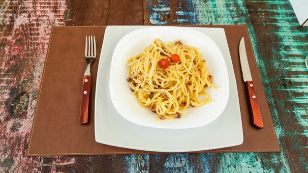 Delicious carbonara spaghetti dish on wooden table