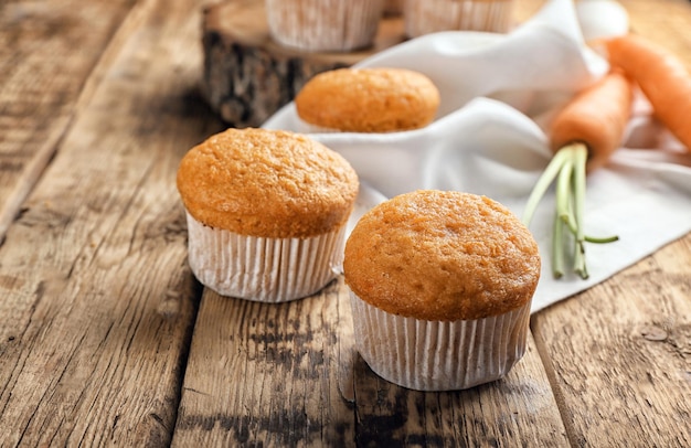 Delicious carrot muffins on wooden table