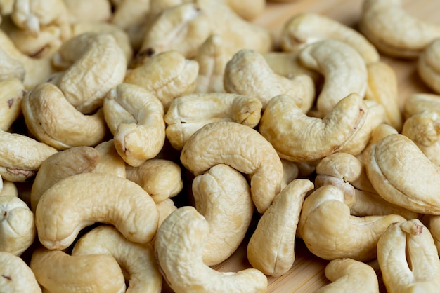 Delicious cashew nuts on a wooden surface ready to eat and peeled cashew nuts