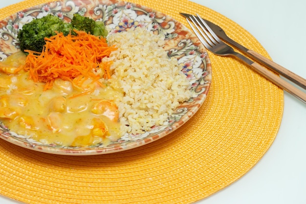 Delicious cassava cream dish with shrimp rice broccoli and grated carrot