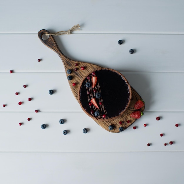 Delicious cheesecake decorated with berries on a wooden board