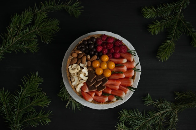 검은 배경에 과일로 장식된 맛있는 치즈 케이크