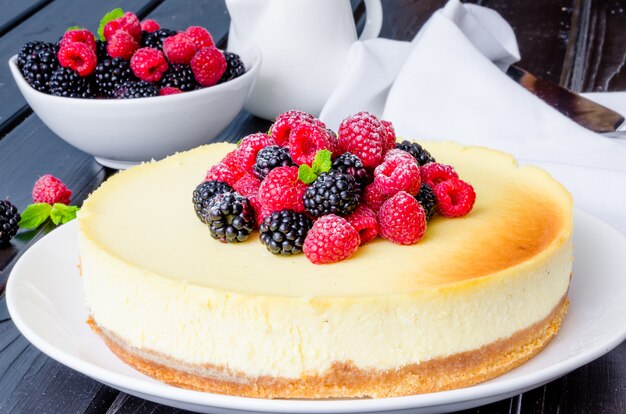 Delicious cheesecake with raspberries and blackberries. Traditional New York cheesecake. American cuisine.