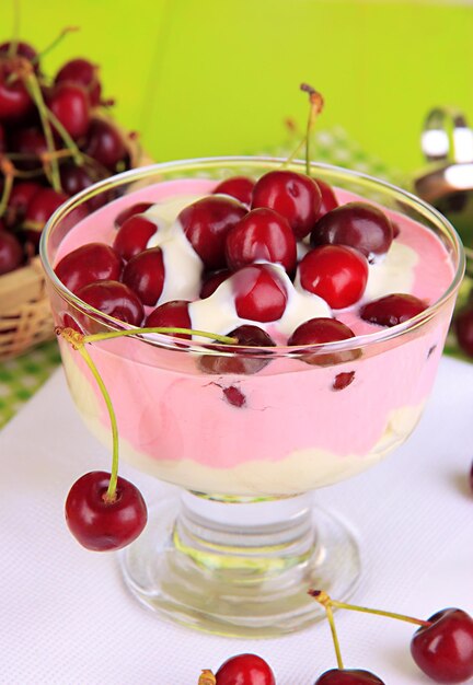 Delicious cherry dessert in glass vase on wooden table closeup