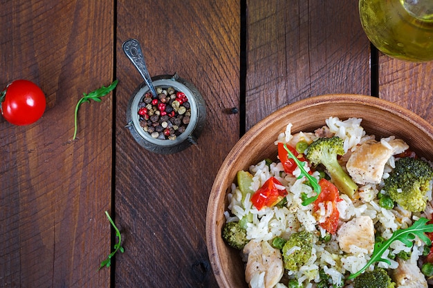 Delicious chicken, broccoli, green peas, tomato stir fry with rice.