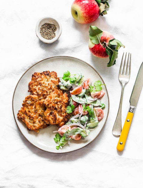 Delicious chicken fillet apple fritters and fresh vegetables yogurt dressing salad on a light background top view