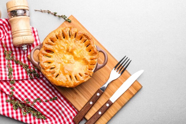 Delicious chicken pot pie in saucepan on wooden board