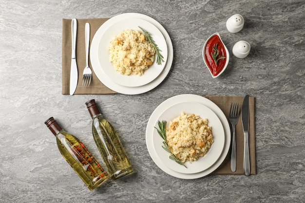 Delicious chicken risotto served on grey table flat lay