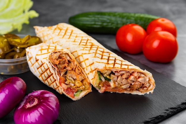 Вкусная куриная shawarma с соусом овощей на доске для резки
