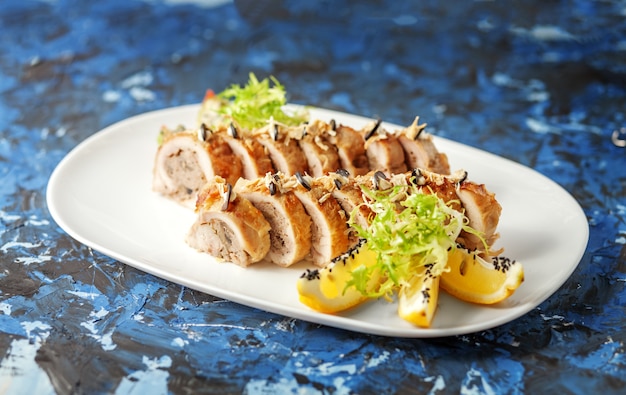 Delicious chicken with sauce rolls on a blue background. The con