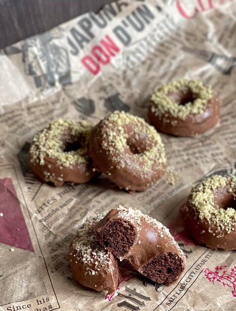 delicious chocolate baked donuts with nuts on newspaper, donuts with chocolate