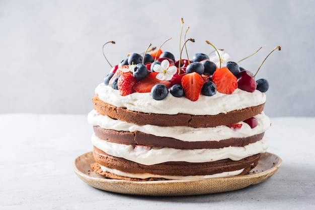 Delicious chocolate biscuit cake with cream cheese and berries