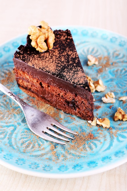 Вкусный шоколадный торт на тарелке на ярком фоне